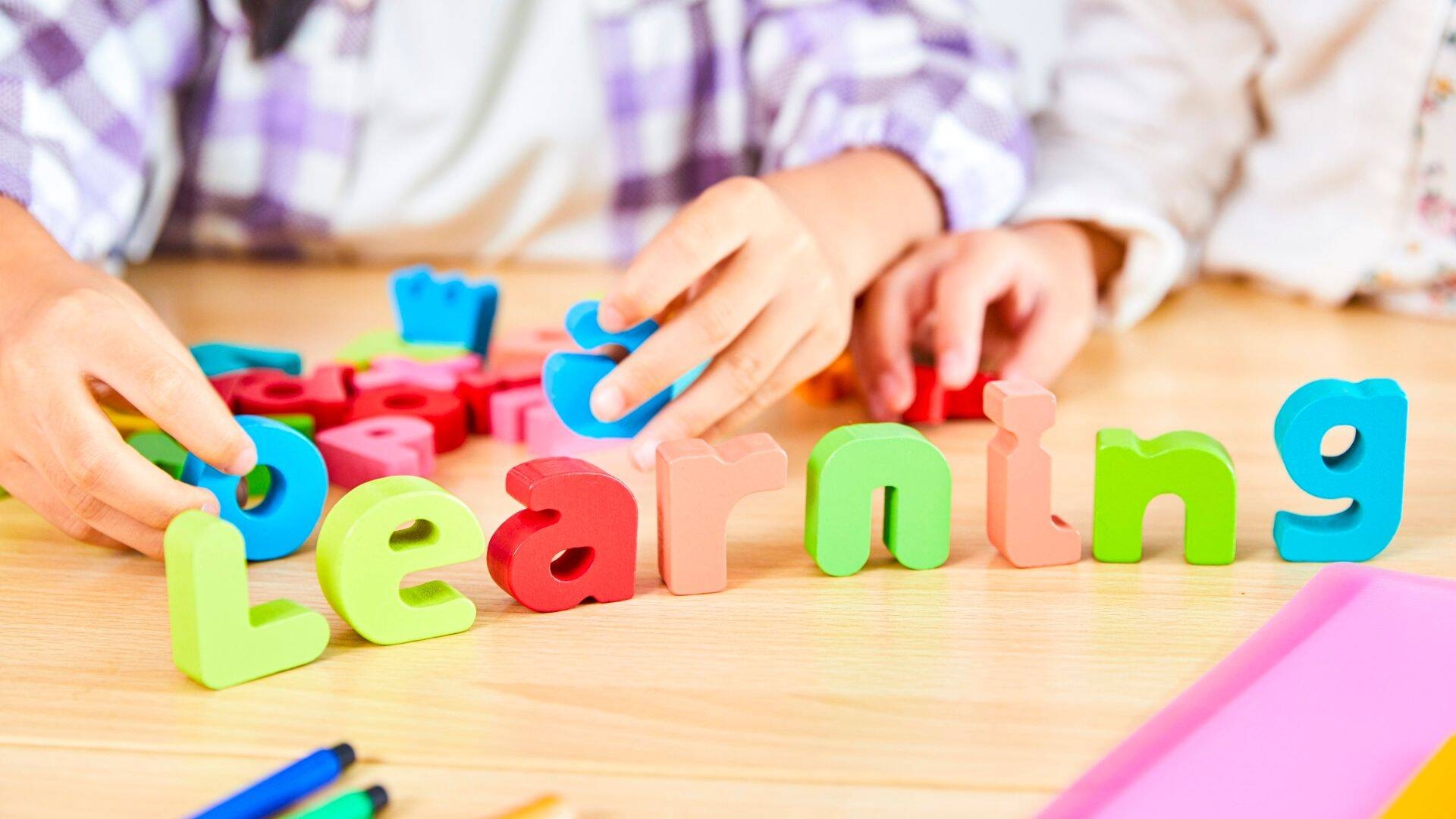 Bambini che compongono la scritta "learning" 