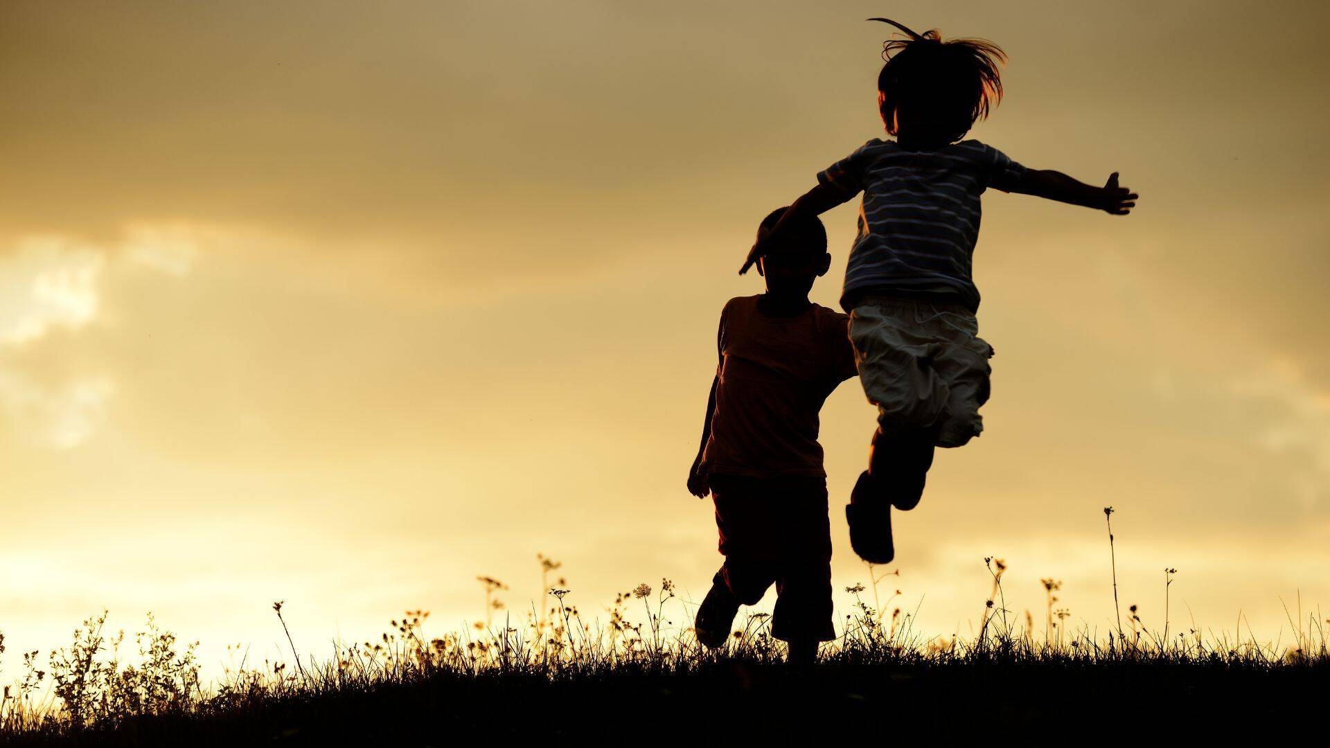 foto bambini al tramonto che saltano