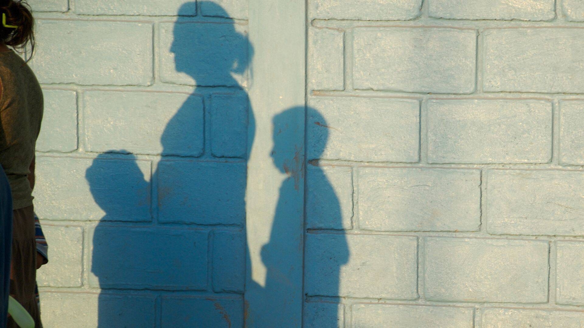 foto di un'ombra di una madre con due figli