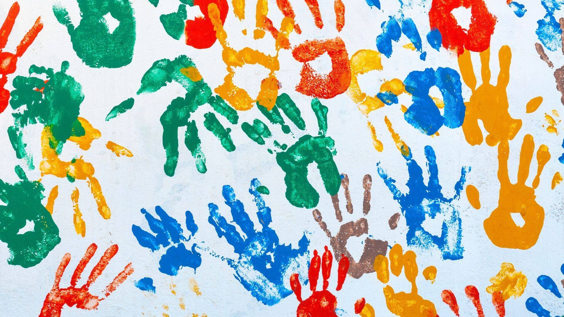 foto di impronte colorate di mani di bambini su fondo bianco